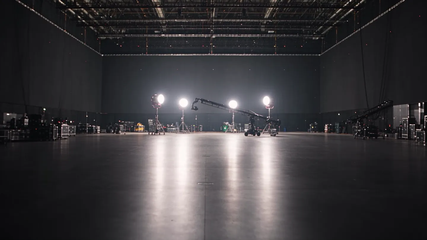 The sound stage: a huge black hall, a row of lit lamps at the far end and their reflection on the floor.